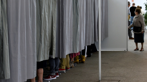 Varias personas en las cabinas preparan sus votos para el 26-J. REUTERS/Eloy Alonso