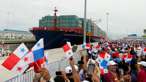 Personas celebrando la inauguración del Canal de Panamá con banderas del país. REUTERS/Carlos Jasso