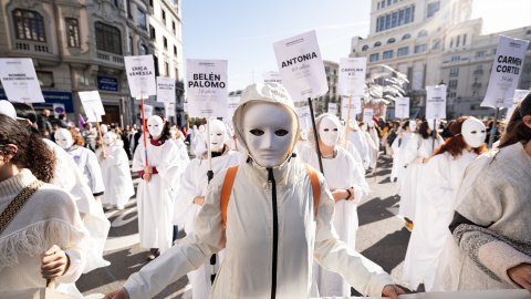 Decenas de personas llevan carteles con nombres de mujeres asesinadas por violencia machista durante una manifestación por el 25N en Madrid.