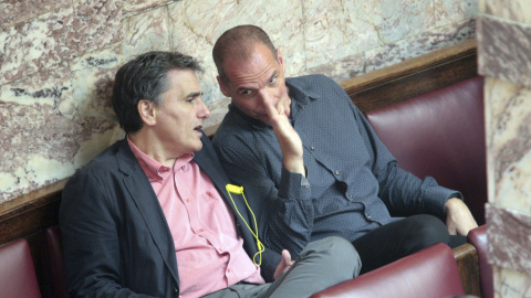 El ministro de Finanzas, Euclides Tsakalotos (i) conserva con su predecesor en el cargo Yanis Varoufakis (d) durante una sesión en el Parlamento en Atenas, Grecia hoy 9 de julio de 2015. El portavoz del Gobierno griego, Gavriil Sakelaridis,