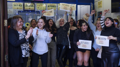 Varias personas celebran en la sucursal Doña Manolita de Madrid, que ha vendido décimos de los números 01.568 y 88979, dos de los quintos premios.