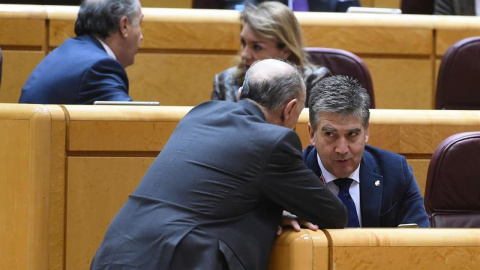 El portavoz del PP en el Senado, Ignacio Cosidó (d), conversa con un compañero durante el Pleno del Senado donde tiene lugar una votación sobre la proposición de ley orgánica de reforma de la ley del Poder Judicial sobre medidas urgentes en