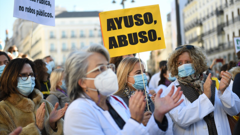 Un grupo de personas con un cartel donde se puede "Ayuso, abuso" en una concentración en defensa de la Atención Primaria, a 13 de noviembre de 2021, en Madrid, (España).