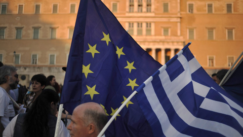 Un manifestante ondea una bandera de la Unión Europea y de Grecia durante una manifestación a favor de la zona euro en Atenas. EFE