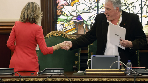 El diputado de EH Bildu, Joseba Asiron (d) estrecha la mano a su predecesora en el cargo, Cristina Ibarrola (i) tras proclamarse alcalde de Pamplona tras la moción de censura en el Ayuntamiento de Pamplona.