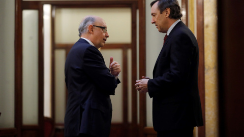 El ministro de Hacienda, Cristobal Montoro, conversa con el portavoz parlamentario del PP, Rafael Hernando, en los pasillos del Congreso, momentos antes del inicio de la sesión de control al Gobierno en el Congreso de los Diputados. EFE/Jua