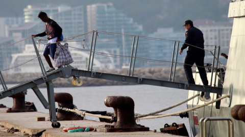 30/08/2019.- Uno de los quince migrantes rescatados por el barco Open Arms, y que ha viajado desde Italia a bordo del Audaz de la Armada española, desciende del buque a su llegada este viernes al muelle de Crinavis, en San Roque (Cádiz). EF