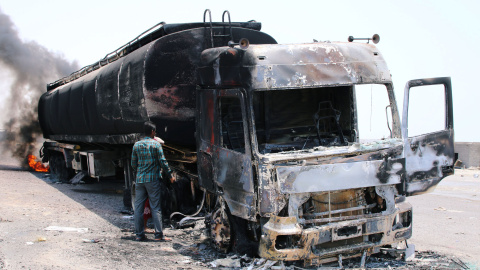 Un hombre inspecciona un camión incendiado durante los enfrentamientos en el sur de Yemen. / Reuters