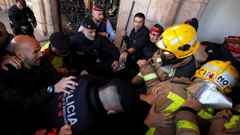 Enfrentamiento entre bomberos catalanes y agentes de los Mossos d'Esquadra a las puertas del Parlament, en las protestas de finales de noviembre. REUTERS/Albert Gea