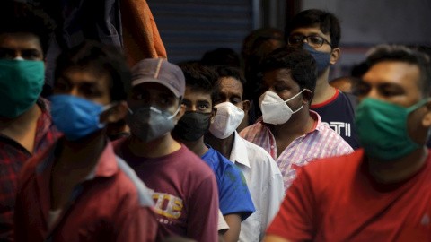 Ciudadanos con mascarilla pero sin distancia social hacen cola a las puertas de una tienda en la ciudad de Kolkata (India) este sábado 15 de mayo de 2021.