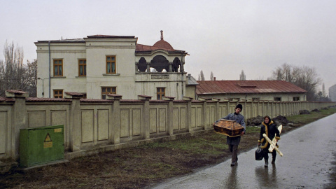 Unos padres rumanos llevan un pequeño ataúd donde va el cuerpo de bebé, muerto por el sida en un hospital de Bucarest (6 de febrero de 1990). REUTERS / Radu Sigheti