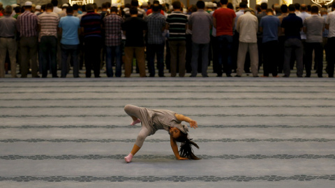 Una niña juega mientras un colectivo asiste a las oraciones de la noche en la mezquita de Ahmet Hamdi Akseki en Ankara, Turquía. REUTERS / Umit Bektas