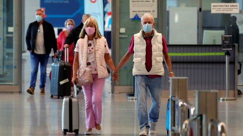 Una parejas de turistas, procedentes de un vuelo del Reino Unido, en la terminal del aeropuerto de Malaga-Costa. REUTERS/Jon Nazca