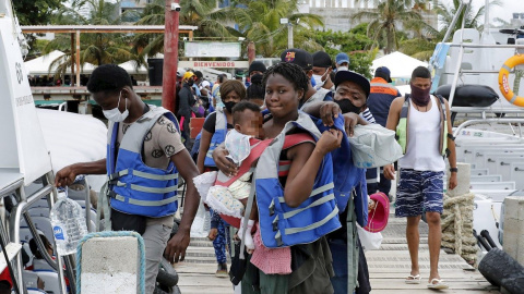 Migrantes de diversas partes del mundo esperan para abordar una embarcación que los lleve al otro lado del golfo de Urabá, el 3 de mayo de 2021, en Necoclí (Colombia).