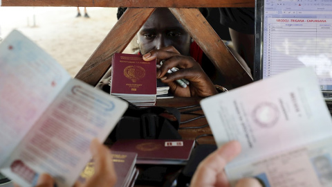 Migrantes de diversas partes del mundo compran boletos para una embarcación que los llevará al otro lado del golfo de Urabá, el 3 de mayo de 2021, en Necoclí (Colombia).