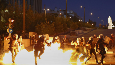 Una bomba incendiaria explota en medio de un grupo de antidiasturbios de la policía griega. EFE/ Yannis Kolesidis