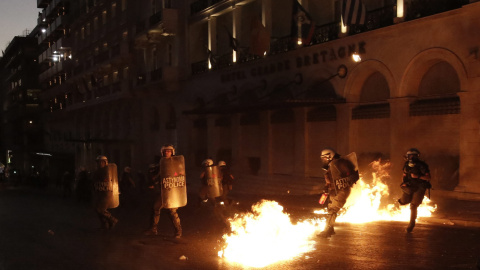 Los antidisturbios de la policía griga, acosados por el lanzamiento de cócteles molotov por parte de los manifestantes. EFE/ YANIS KOLESIDIS