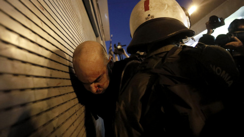 Un manifestante, herido durante los disturbios que tuvieron lugar tras la manifestación, es detenido por la policía griega. EFE/ YANNIS KOLESIDIS