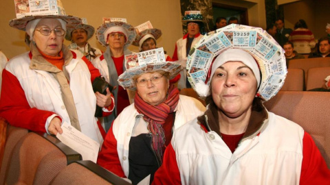 Un grupo de mujeres con sombreros echos con boletos.