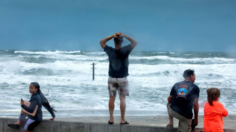 Varias personas observan la llegada del huracán Dorian en la playa de Daytona, en Florida. / EFE