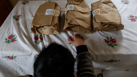 Un niño durante la comida en su casa del barrio madrileño de Carabanchel momentos antes de abrir el menú de la ONG del chef José Andrés, que reparte en Madrid a las familias más necesitadas durante el estado de alarma provocado por el coron