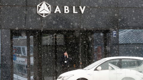 Un guardia de seguridad habla por su teléfono móvil en la entrada de la sede del banco ABLV, en Riga, la capital de Letonia. REUTERS/Ints Kalnins