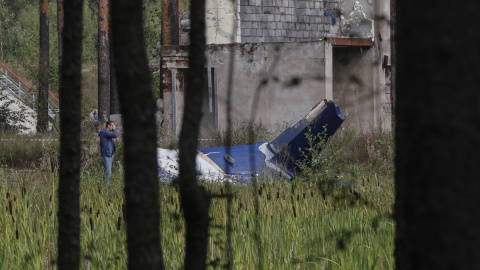 Un hombre inspecciona los restos del avión en el que viajaba el jefe del Grupo Wagner, Yevgeni Prigozhin, que se estrelló cerca de la aldea de Kuzhenkino, en la región rusa de Tver. EFE/EPA/ANATOLY MALTSEV