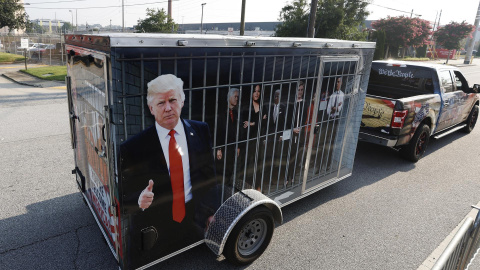 Un seguidor del expresidente estadounidense Donald Trump con un remolque que muestra imágenes de líderes demócratas en una celda, a las puertas de la cárcel del condado de Fulton, en Atlanta, Georgia, este 24 de agosto de 2023.