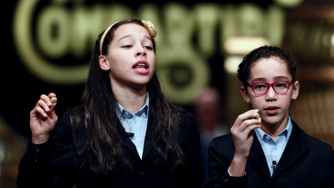 Los niños de San Ildefonso Noura Akrouh (d) y Elizabeth del Carmen Roque (i) muestran el número 04211 que ha sido agraciado con tercer premio. / EFE