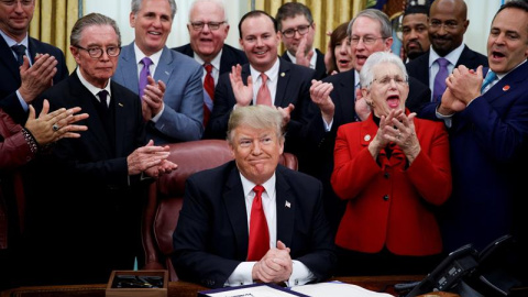 El presidente de EE.UU., Donald Trump (C), preside la ceremonia de firma de la "ley del primer paso" y de la "ley de reforma de justicia juvenil" en la Oficina Oval de la Casa Blanca, en Washington DC (Estados Unidos) hoy, 21 de diciembre d