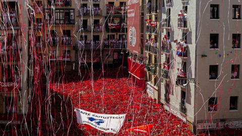 Miles de personas muestran en alto el tradicional "pañuelico" rojo en la Plaza del Ayuntamiento de Pamplona durante el lanzamiento del chupinazo. / VILLAR LÓPEZ (EFE)