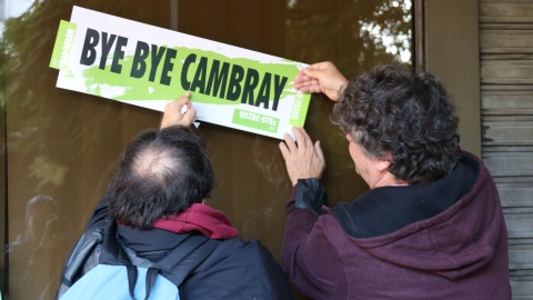 Dos delegats sindicals enganxant una pancarta en contra del conseller d'Educació.