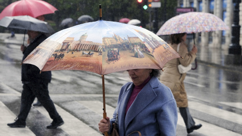 22-11-Una mujer se protege de la lluvia caía en Oviedo, a 20 de noviembre de 2023.