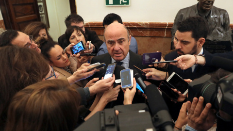 El ministro de Economía, Luis de Guindos, contesta a las preguntas de los periodistas tras el pleno celebrado en el Congreso de los Diputados. EFE/Ballesteros