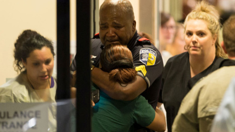 Varias personas junto a un policía de Dallas en un hospital. REUTERS