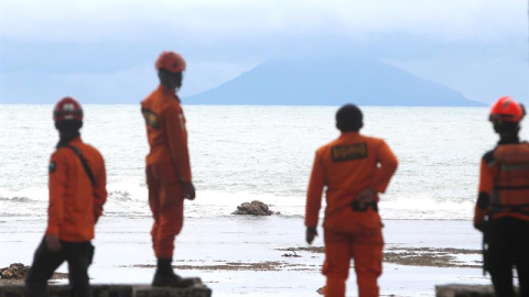 Miembros de los servicios de rescate observan el volcán Anak Krakatau desde la playa Carita en Indonesia hoy, 26 de diciembre de 2018. Las autoridades de Indonesia elevaron hoy a 430 los muertos en el tsunami que golpeó el sábado el litoral