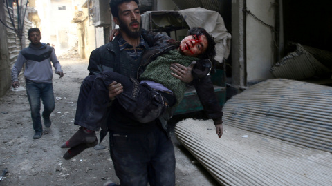 Un joven traslada a un niño herid por los bombardeos en la ciudad siria de Guta, cerca de Damasco. REUTERS/Bassam Khabieh