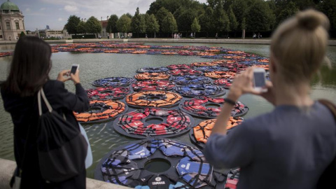 Dos mujeres toman fotos de la obra "F Lotus" del artista chino Ai Weiwei en los jardines del Palacio Belvedere durante la presentación a la prensa de la exposición "AI WEIWEI traslocación-transformación"en Viena (Austria). EFE/Christian Bru