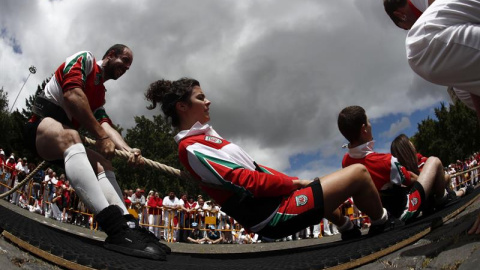 Dos miembros del equipo Berriozar Kirol Elkartea de Sokatira (tiro de cuerda), durante el torneo de San fermín de Sokatira 4x4 mixto, dentro de los campeonatos de deporte rural que tienen lugar en la pamplonesa plaza de Los fueros. EFE/Javi