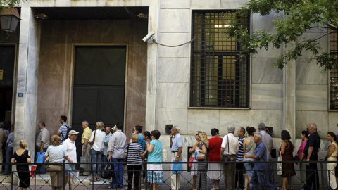 Un grupo de personas hace cola para realizar sus transacciones en el Fondo de Depósitos y Préstamos en Atenas. EFE/Orestis Panagiotou