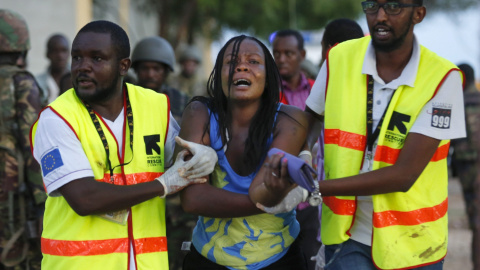 Dos sanitarios ayudan a una mujer que ha escapado de la Universidad de Garissa, en el este de Kenia, donde al menos 147 personas han muerto en un ataque con rehenes reivindicado por el grupo islamista Al Shabab.- Dai Kurokawa (EFE)