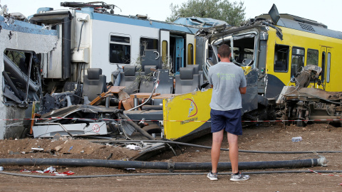 Un hombre mira los restos en el lugar donde dos trenes de pasajeros chocaron en medio de un olivar en la localidad meridional de Corato , cerca de Bari , Italia.- REUTERS