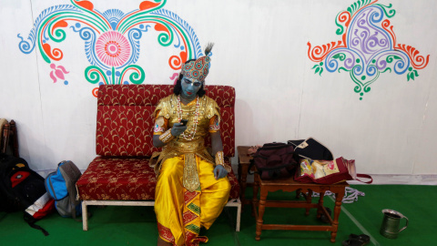 Artista caracterizado como Krishna usa su teléfono móvil mientras espera para llevar a cabo el último día de la semana de celebración del Señor Jagannath " Rath Yatra " , o la procesión del carro, en Calcuta , India.- REUTERS