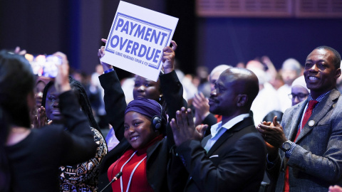 Nakeeyat Dramani Sam, un activista climático, sostiene un cartel con el lema "pago atrasado" en una sesión informativa de la Cumbre del Clima de Sharm el Sheikh, Egipto.