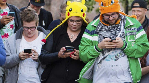 Un grupo de personas mientras juegan al videojuego "Pokémon Go" con sus móviles, en Leerdam, Holanda. EFE/Piroschka Van De Wouw