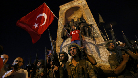 Militares turcos hacen guardia en la Plaza Taksim de turquía mientras ciudadanos turcos ondean la bandera del país. REUTERS/Murad Sezer