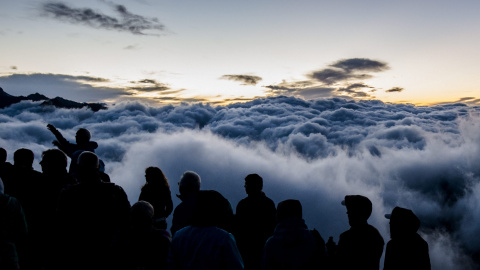 Turistas esperan a la salida del sol sobre el lecho de niebla asentado en la falda de la montaña Eggishorn, de 2.927 metros de altura sobre el nivel del mar, en Fiesch (Suiza), hoy, 28 de julio de 2015. EFE/Dominic Steinmann