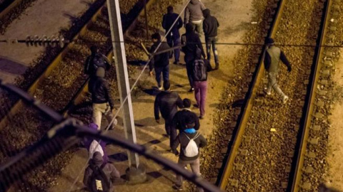 Varios inmigrantes intentan cruzar por las vías del Eurtúnel./ AFP