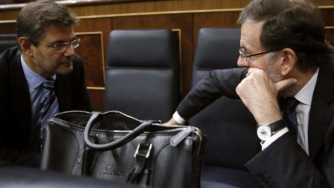 El ministro de Justicia Rafael Catalá conversa con el presidente del Gobierno Mariano Rajoy durante un plenio en el Congreso de los Diputados. EFE