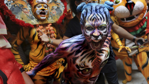 Bailarines indios, pintados y disfrazados de tigres, actúan durante el Día Internacional del Tigre en Calcuta, India, hoy 29 de julio de 2015. Varios estudiantes de Calcuta tratan de sensibilizar a la población sobre la difícil situación de